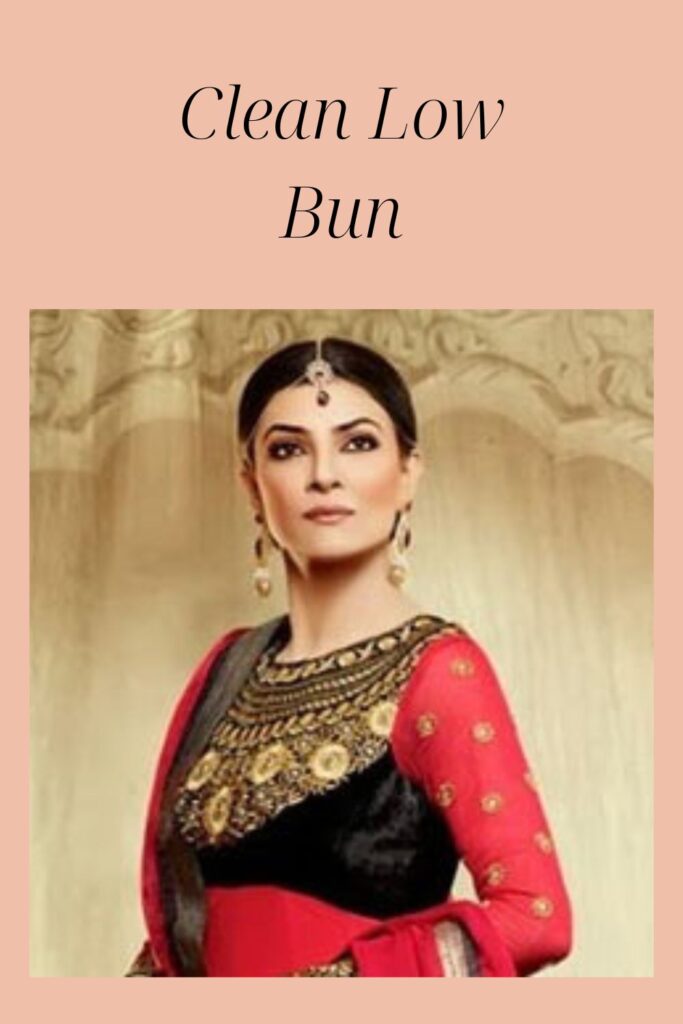 Sushmita Sen in red and black traditional outfit with matching jewellery showing her clean low bun - latest Indian women hairstyles