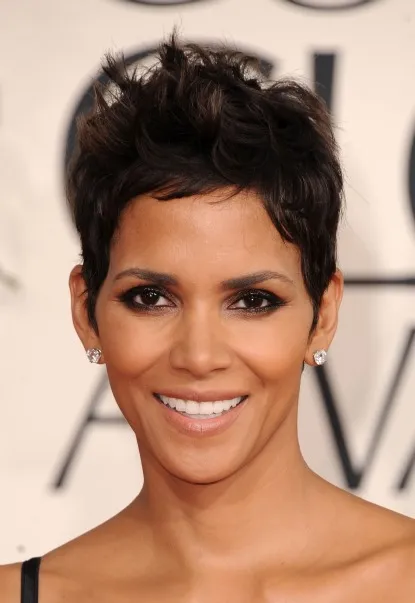 Smiling Halle Berry in black strappy dress and stud earing posing for camera - hollywood actresses new short hair