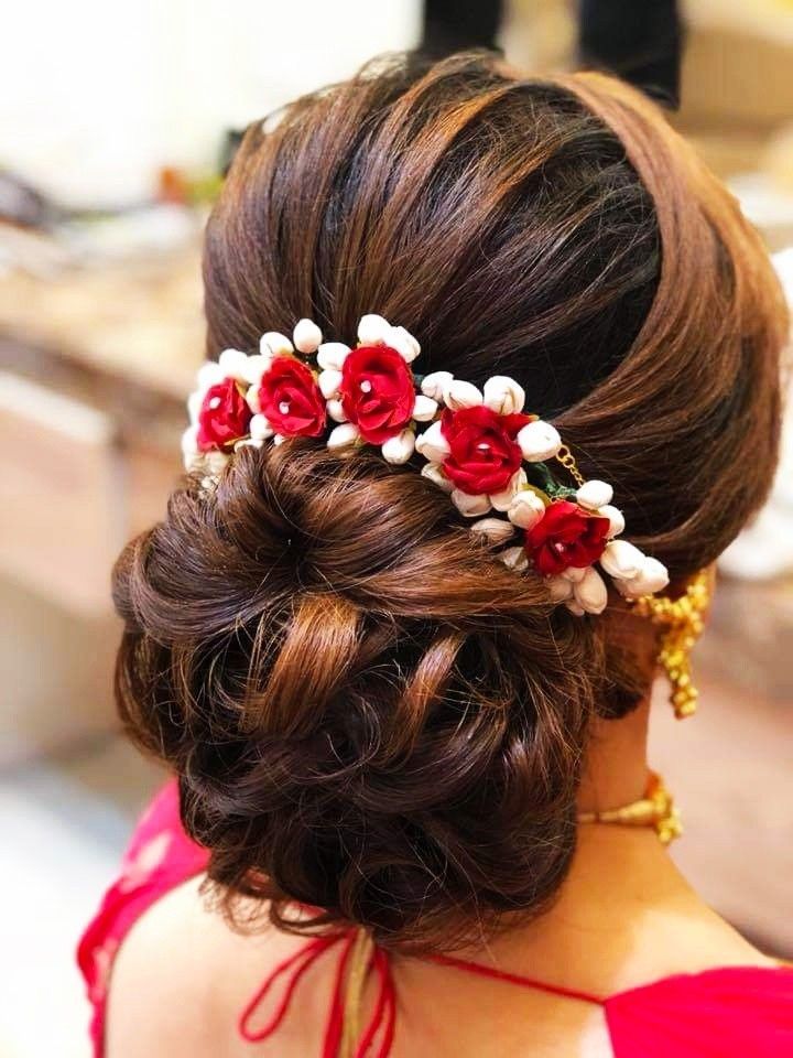 A women in red saree showing the back view of her heavy bun - hairstyles for girls with curly hair
