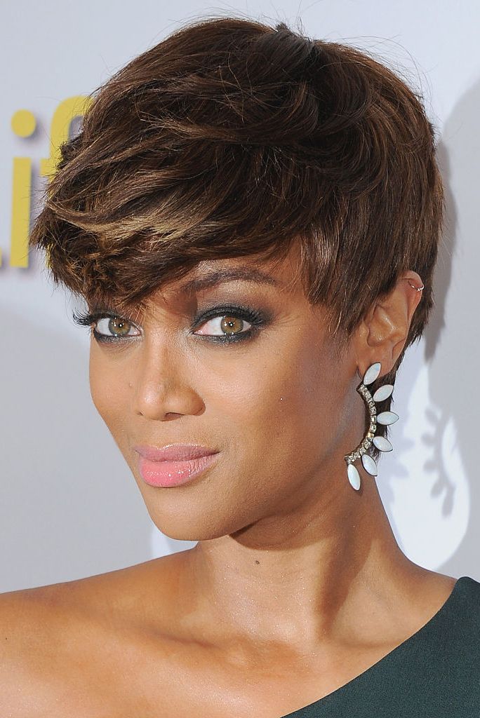 Tyra Banks in one shoulder dress with white drop earring posing for camera - celebriity short hair cuts