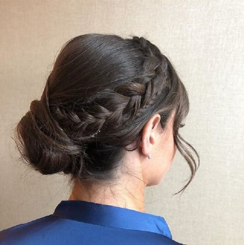 A girl in blue shirt showing the back view of her braided bun - hairstyles for girls with long hair