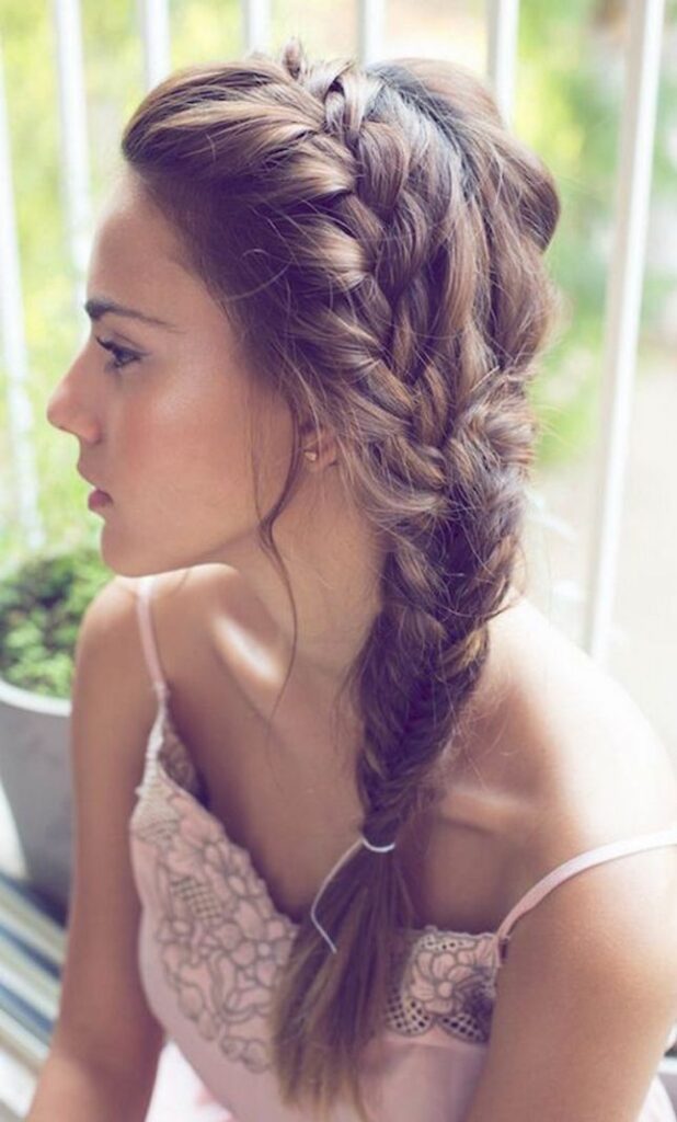 A girl in pink strappy dress showing the side view of her braided hairstyle - hairstyles for girls with medium hair