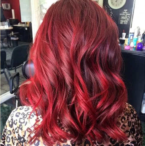 A girl in printed shirt showing the back view of her cherry red hair color - dark red hair dye