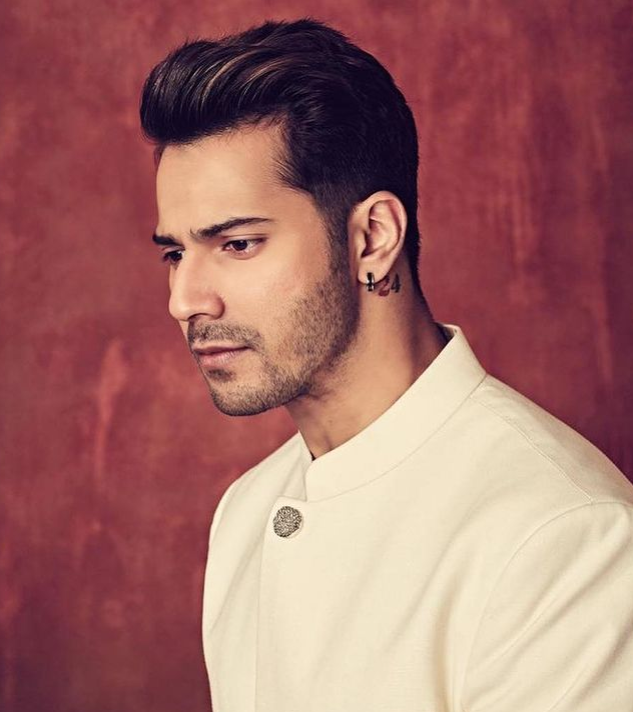 Varun Dhawan in White traditional attire with a black earring showing his side cut, which follows by straight hair - Varun Dhawan Haircut