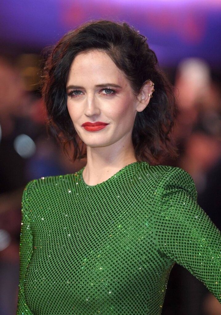 Eva Green in green shimmery dress with orange lipstick posing for camera - celebrity short hair cuts