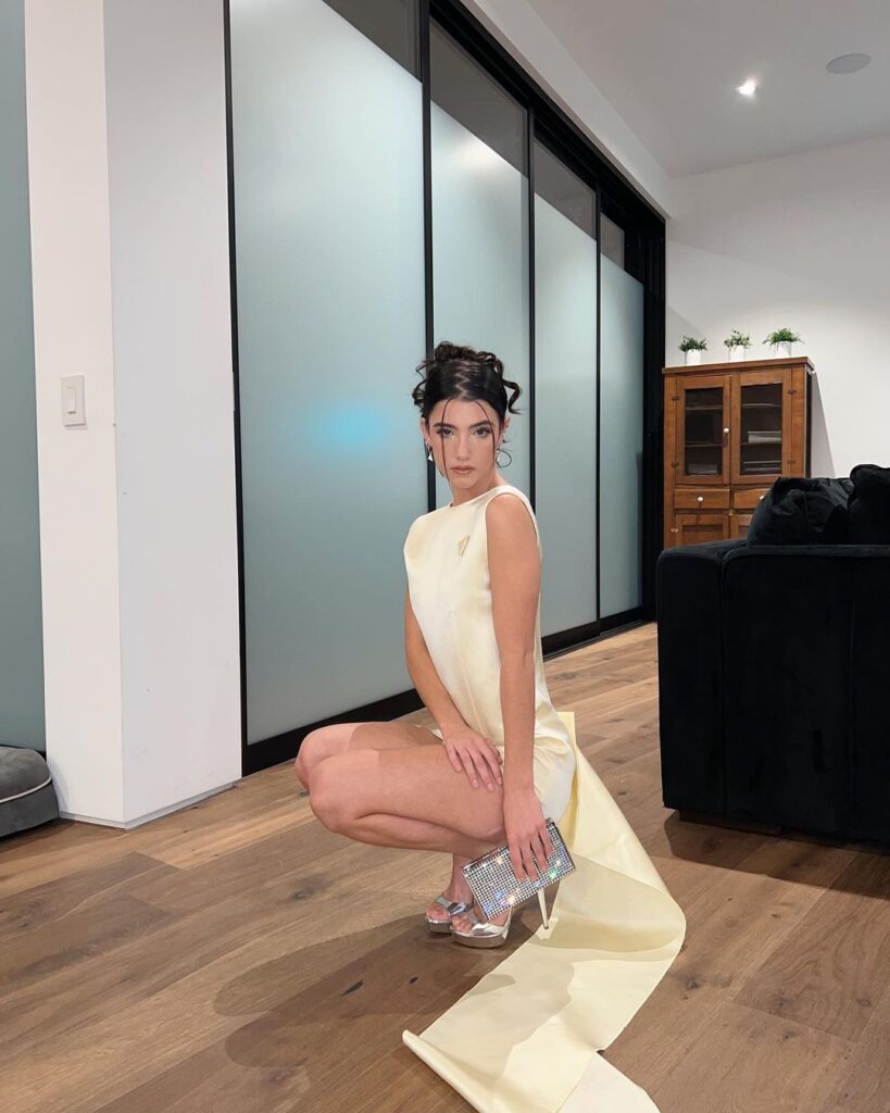 A girl in off white short with high heels and clutch showing her Bun With Zig-Zag Part and Two Strand Bangs - hairstyles for girls with medium hair