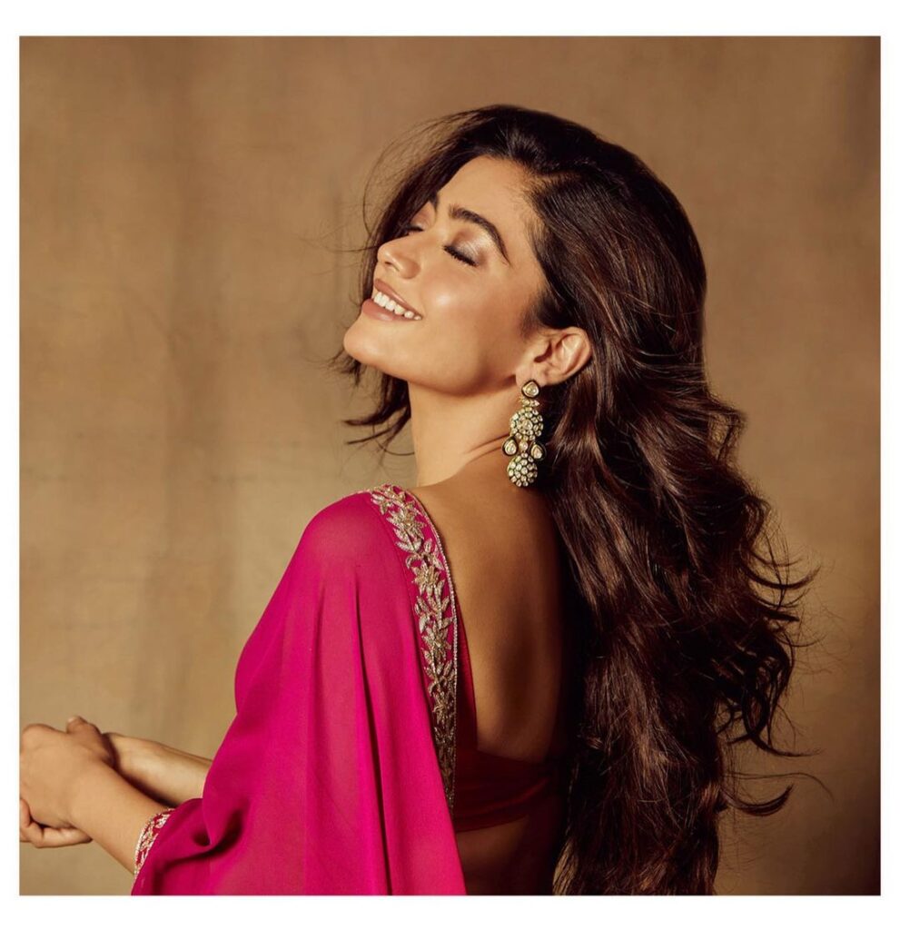 Rashmika Mandana in pink saree with danglers and posing for camera - bollywood actress with long hair
