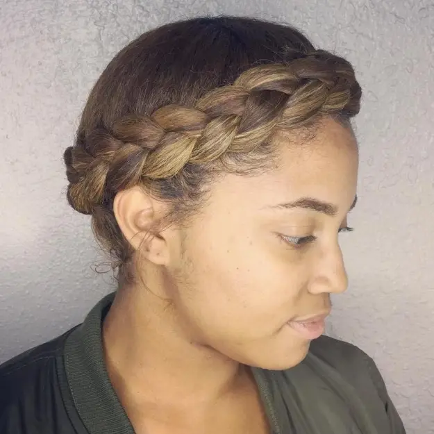 A girl in grey dress posing for camera and showing the side view of her Golden Halo Braid hairstyle - best American hairstyle