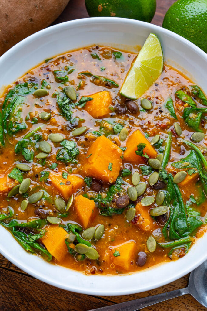 Chipotle and Sweet Potato Stew serves with lemon in a white bowl - high protein diet for weight loss in vegetarians