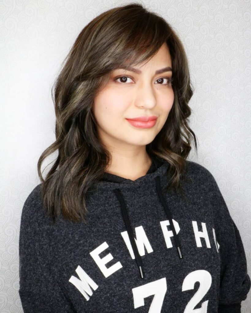 A girl in black hoodie showing her mid length hair with tiny fringes - hairstyles for girls