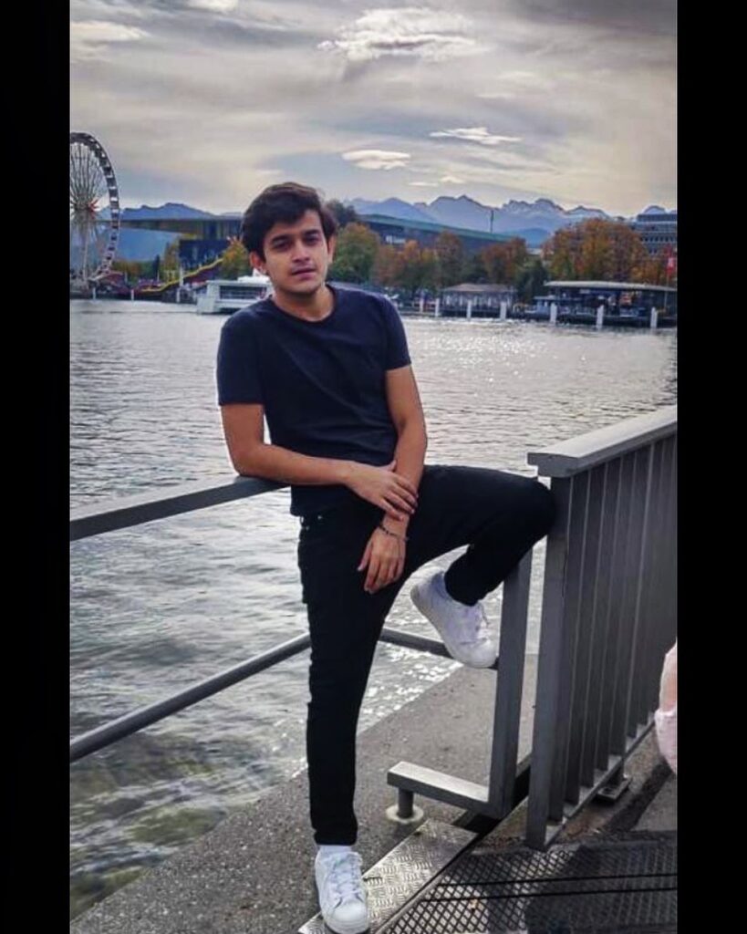 Pravisht Mishra in black t-shirt with black jeans and white sneakers posing for camera  on a river bridge - most handsome tv actors indian 2022