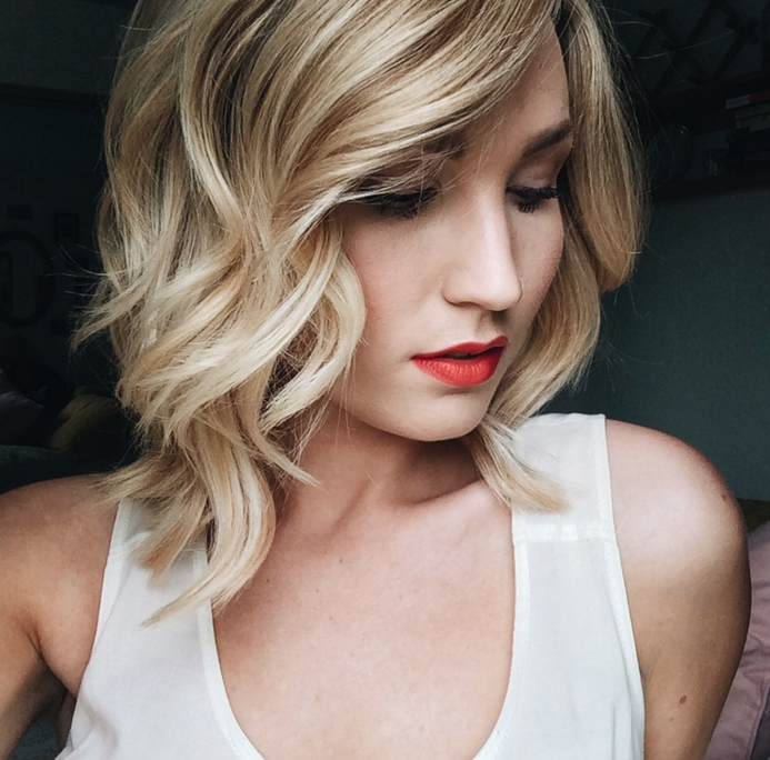 A girl in white tank top and red lipstick with Wavy Blond Haircut - hairstyles for girls with medium hair