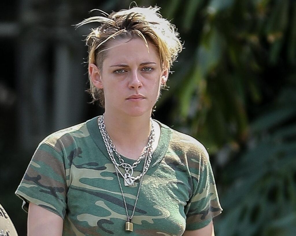 Kristen Stewart without makeup in army printed round neck t-shirt with multiple silver chains - hollywood actress no makeup photos