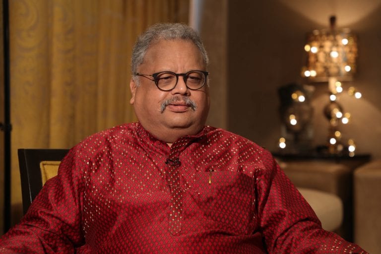Rakesh Jhunjhunwala in maroon kurta with spectacles sitting on a chair - bollywood celebrities who passed away in 2022 