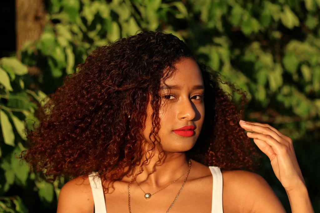 Woman in white strappy dress and The All Natural one hair - 2022 trendy haircuts