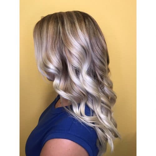 A women in blue half sleeves top showing the side view of her Icy Blonde Waves - short hair