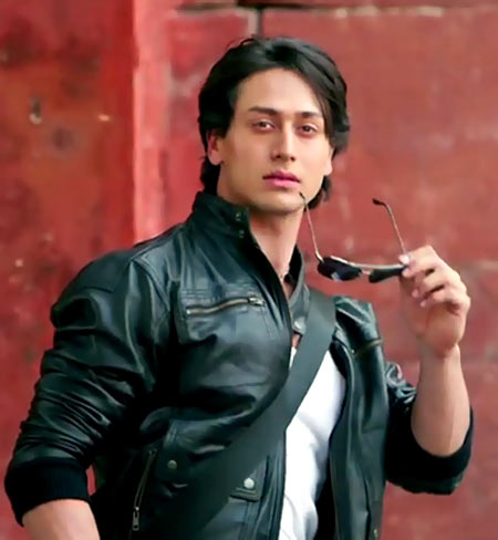 Tiger Shroff in black leather jacket with white t-shirt and goggles in his hand - tiger shroff hairstyle photos