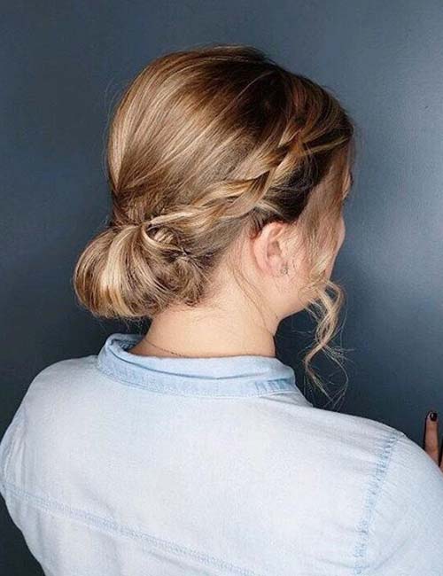 A girl in sky blue shirt showing the back view of her Braided Low Bun - professional hairstyles for curly hair