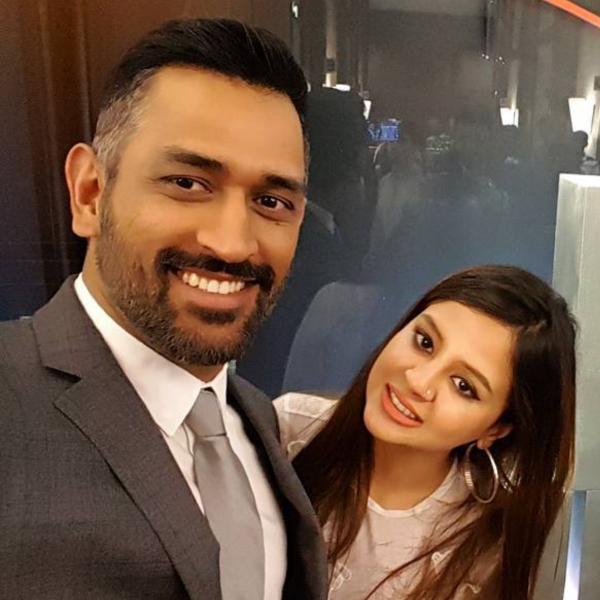 Smiling MS Dhoni and Sakshi Singh Dhoni posing for a selfie - indian cricketers and their wives