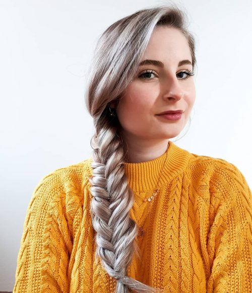 A women in yellow pullover showing her Side Braid hairstyle - professional hairstyles for work