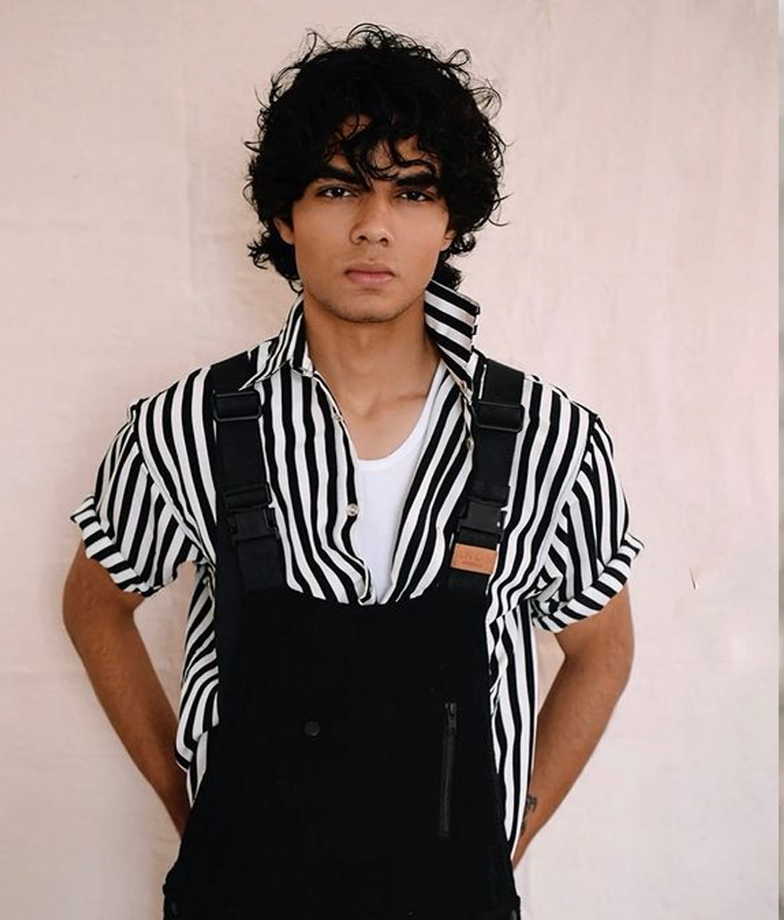Man in black dungaree with black and white lining shirt and Wavy Mop hairstyles - hair style for young man