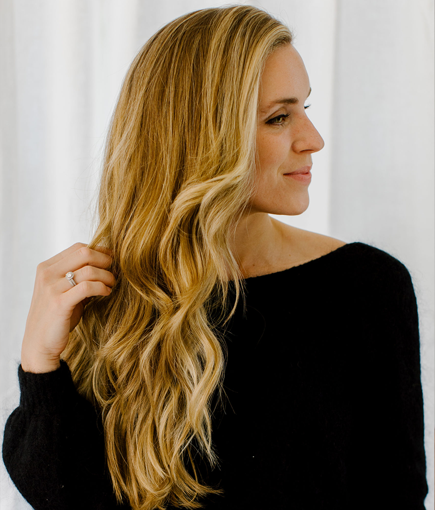 Woman in boat neck black dress showing the side view of her Lush Curls hairstyle Woman in boat neck black dress showing the side view of her Lush Curls hairstyle - long haircut for women