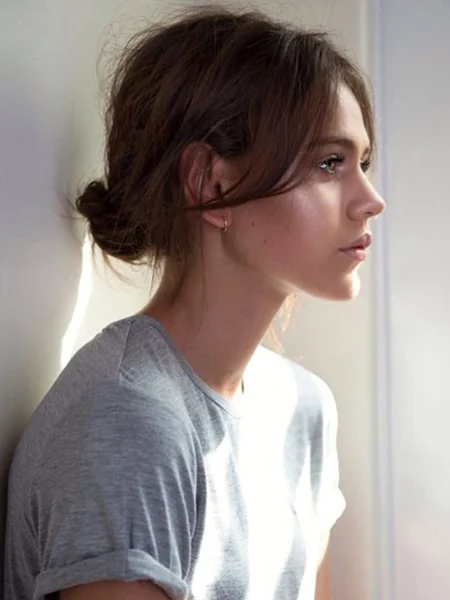 Woman in grey t-shirt and low bun - best simple hairstyles