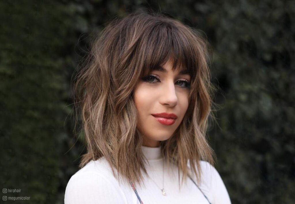 Woman in high neck white dress and Textured Modern Bangs hairstyle - 2022 haircuts female