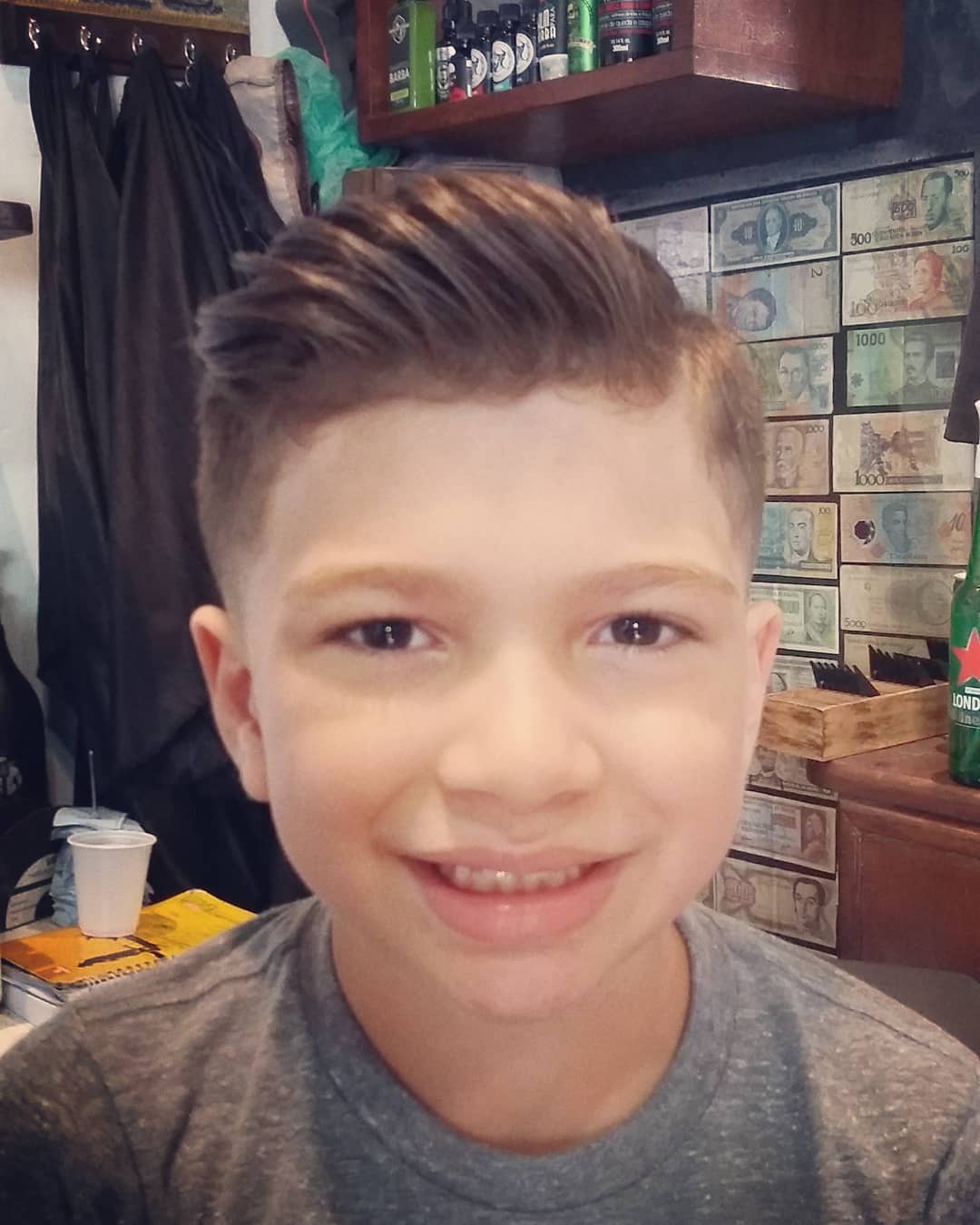 A boy is giving side pose for camera and showing his Classic Pompadour + Low Fade Classic Pompadour + Low Fade