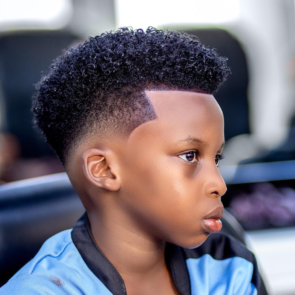 a boy is smiling and setting his High Top hairstyle High Top Fade black boy